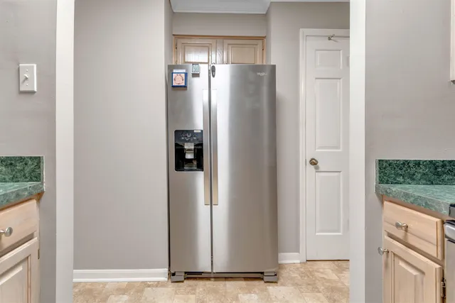a view of a refrigerator in kitchen and a window