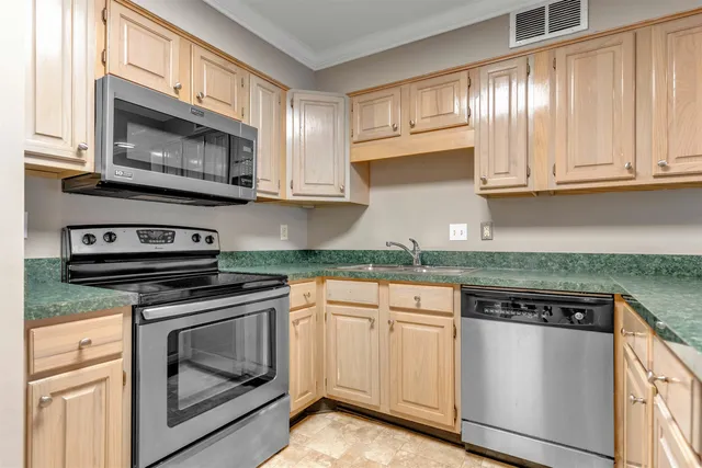 a kitchen with white cabinets and appliances