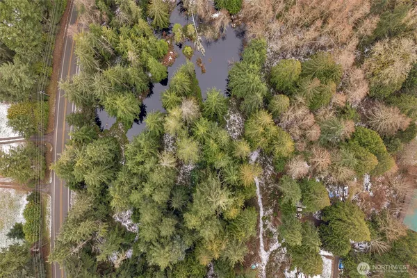 an aerial view of residential houses with outdoor space and trees