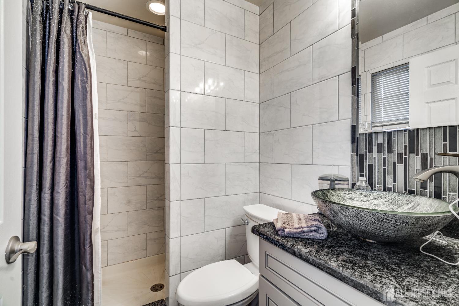 845 B Taylor Road Monroe Township, NJ 08831 - Photo 11 of 15 a bathroom with a granite countertop toilet a sink and shower