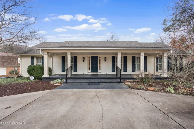 a view of house with a yard and large tree