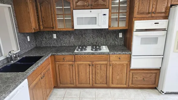 a kitchen with stainless steel appliances granite countertop a sink stove and cabinets