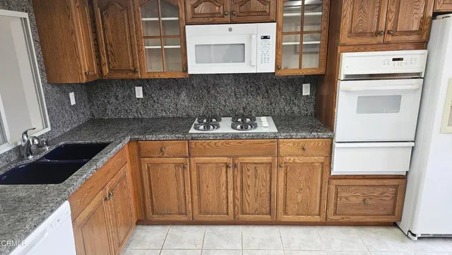 a kitchen with stainless steel appliances granite countertop a sink stove and cabinets