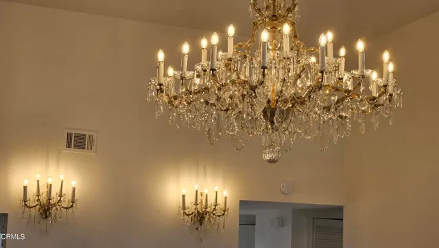 a view of a room with a chandelier fan and windows