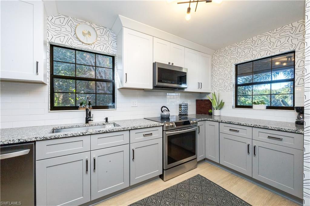 5238 Treetops Drive, Unit L201 Naples, FL 34113 - Photo 14 of 34 a kitchen with stainless steel appliances granite countertop a sink and cabinets