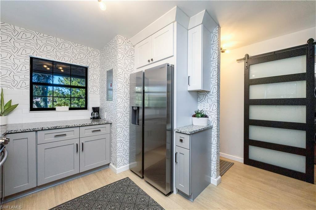 5238 Treetops Drive, Unit L201 Naples, FL 34113 - Photo 15 of 34 a kitchen with stainless steel appliances granite countertop a refrigerator and a sink