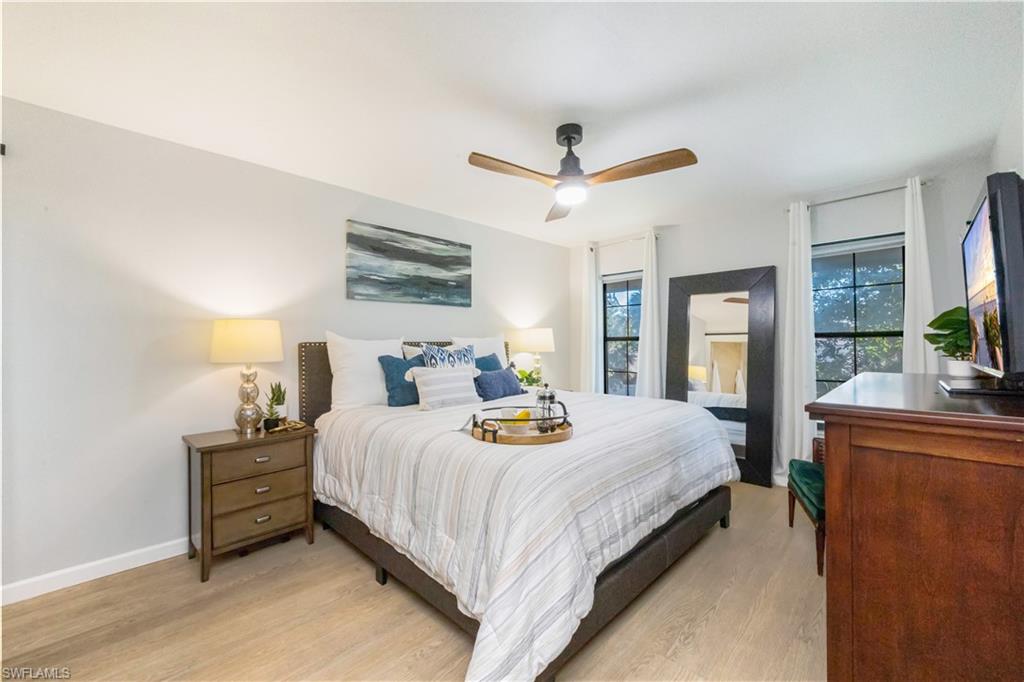 5238 Treetops Drive, Unit L201 Naples, FL 34113 - Photo 16 of 34 a bedroom with a bed a large window and mirror