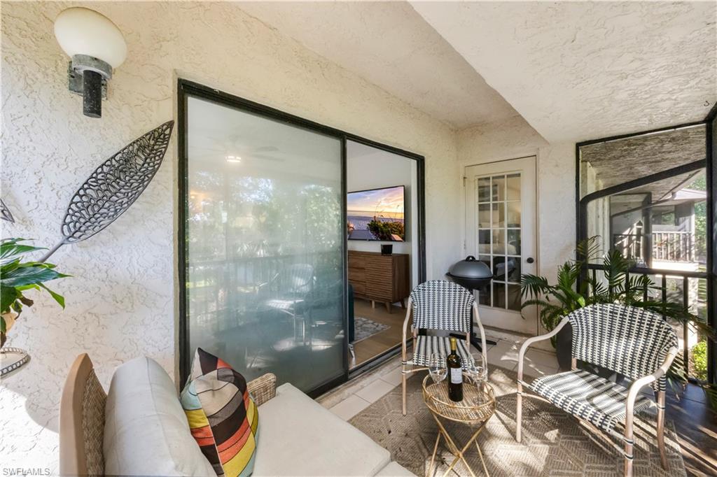 5238 Treetops Drive, Unit L201 Naples, FL 34113 - Photo 27 of 34 a living room with furniture and a floor to ceiling window