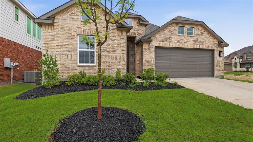 2529 Rivers W Road Anna, TX 75409 - Photo 2 of 40 Brick exterior with an attached two-car garage, concrete driveway, and a manicured front lawn featuring a young tree and landscaped beds