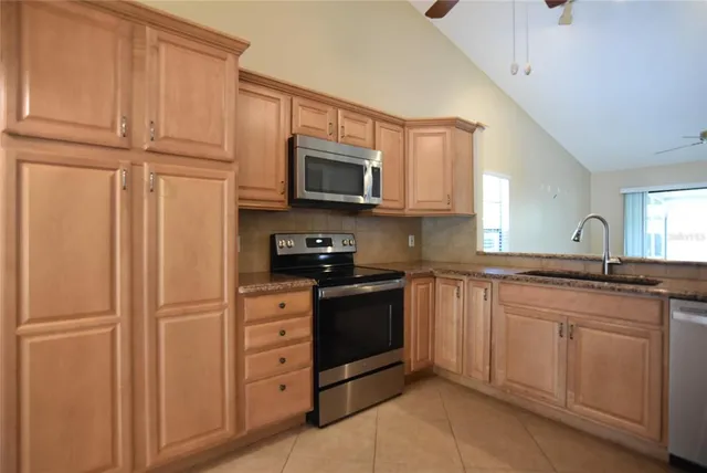 a kitchen with stainless steel appliances granite countertop a refrigerator and cabinets