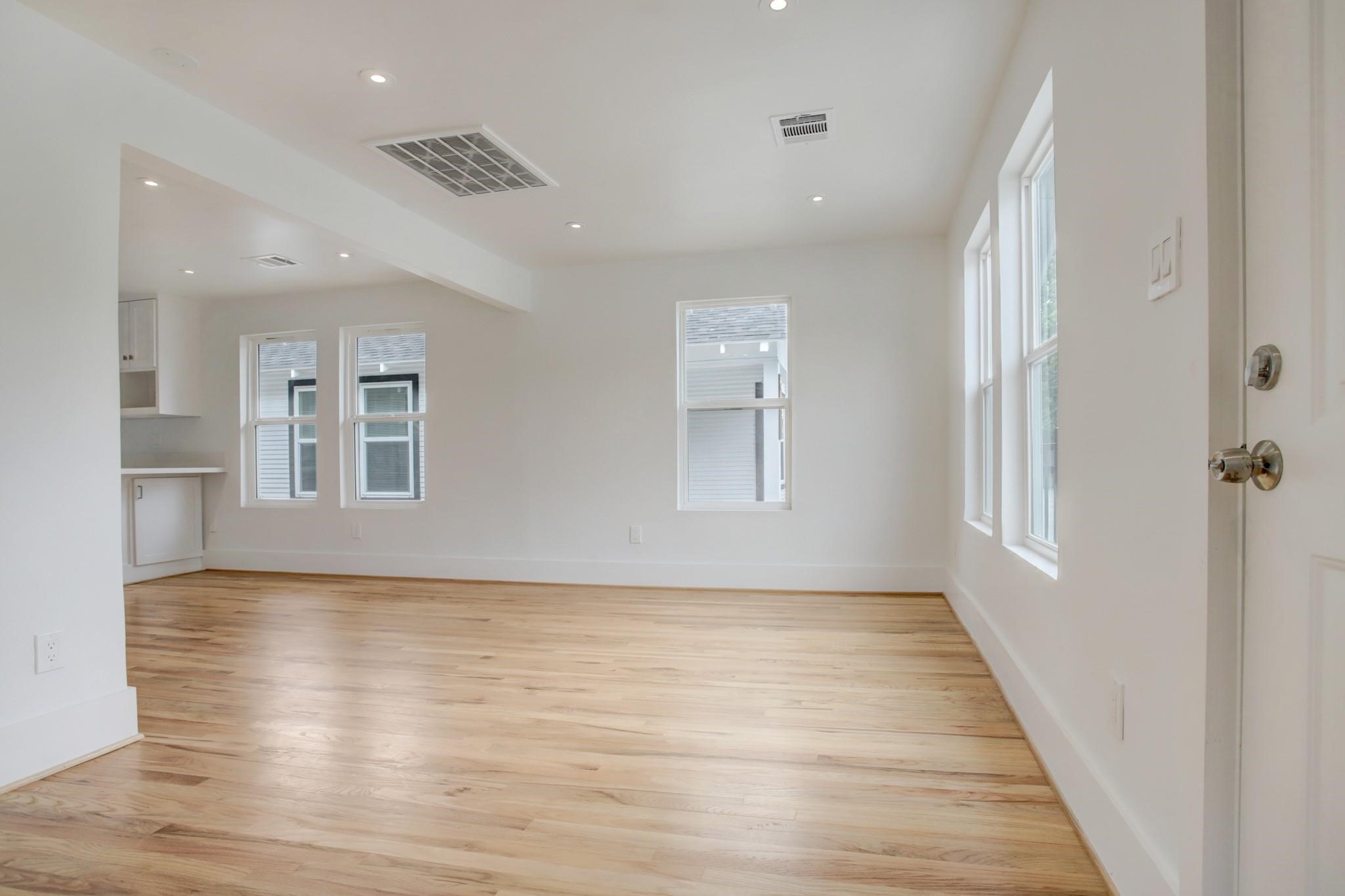 6107 North Main Street Houston, TX 77008 - Photo 6 of 14 a view of an empty room with a window and wooden floor