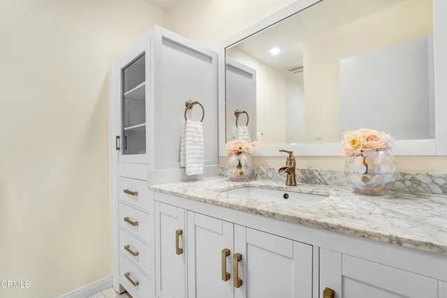 a bathroom with a granite countertop sink and a mirror