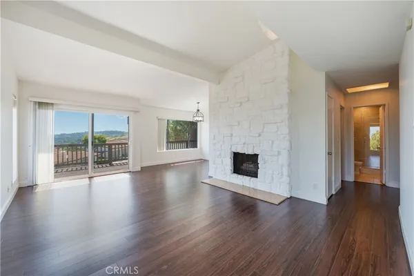 an empty room with wooden floor and fireplace