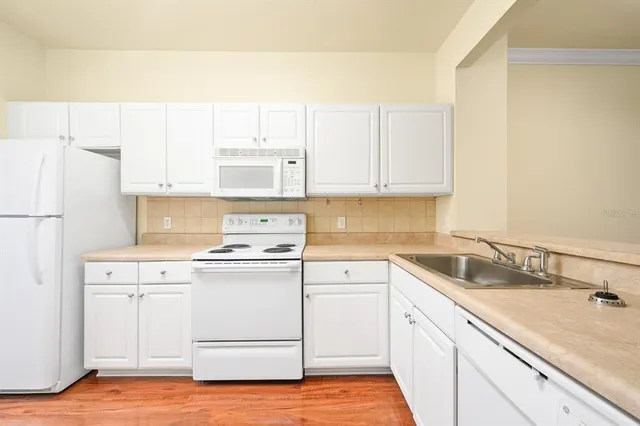 a kitchen with appliances a sink and a refrigerator