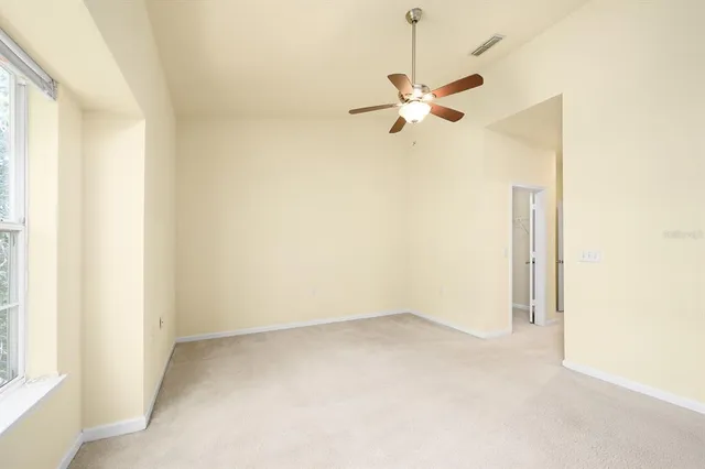 an empty room with a window and a fan