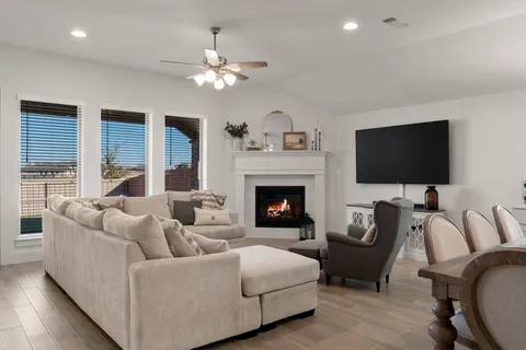 a kitchen with kitchen island granite countertop a sink a refrigerator and chairs