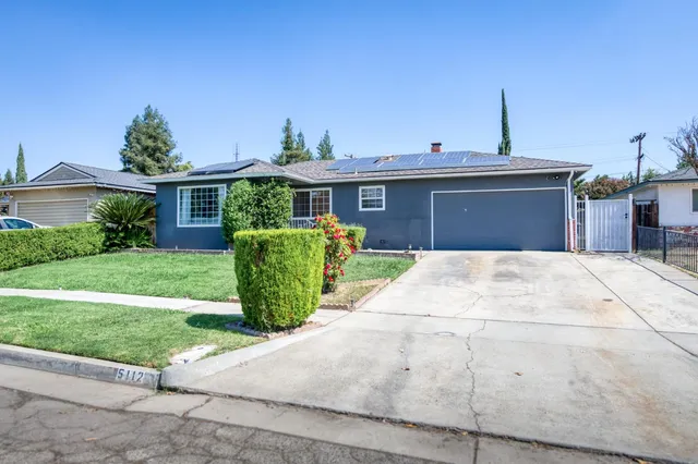 a front view of a house with a garden and plants