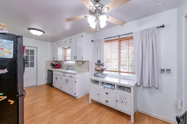 a kitchen with granite countertop a stove a sink dishwasher and a refrigerator with wooden floor