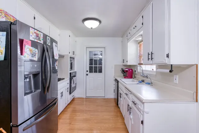 a kitchen with stainless steel appliances a refrigerator sink and cabinets