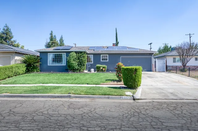 a front view of a house with a garden and plants