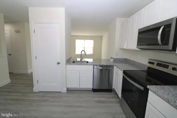 a kitchen with a sink stove and microwave