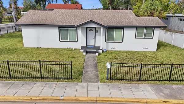 a view of a house with wooden fence next to a road