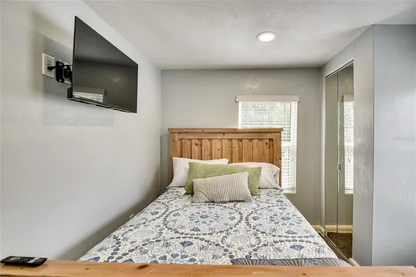 a bedroom with a bed and a flat screen tv