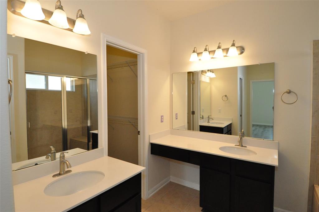 3451 Mayfield Ranch Boulevard, Unit 610 Round Rock, TX 78681 - Photo 11 of 19 Full bath featuring two vanities, a stall shower, a spacious closet, and light tile patterned floors