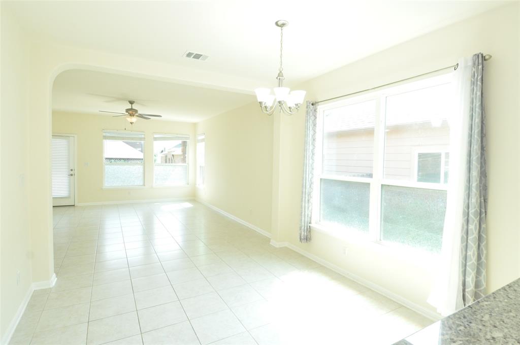 3451 Mayfield Ranch Boulevard, Unit 610 Round Rock, TX 78681 - Photo 5 of 19 Empty room featuring plenty of natural light, light tile patterned floors, ceiling fan, and a chandelier