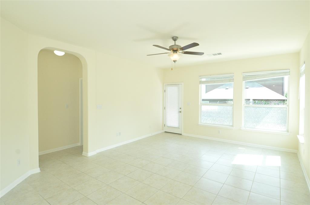3451 Mayfield Ranch Boulevard, Unit 610 Round Rock, TX 78681 - Photo 7 of 19 Empty room featuring arched walkways, light tile patterned floors, and a ceiling fan