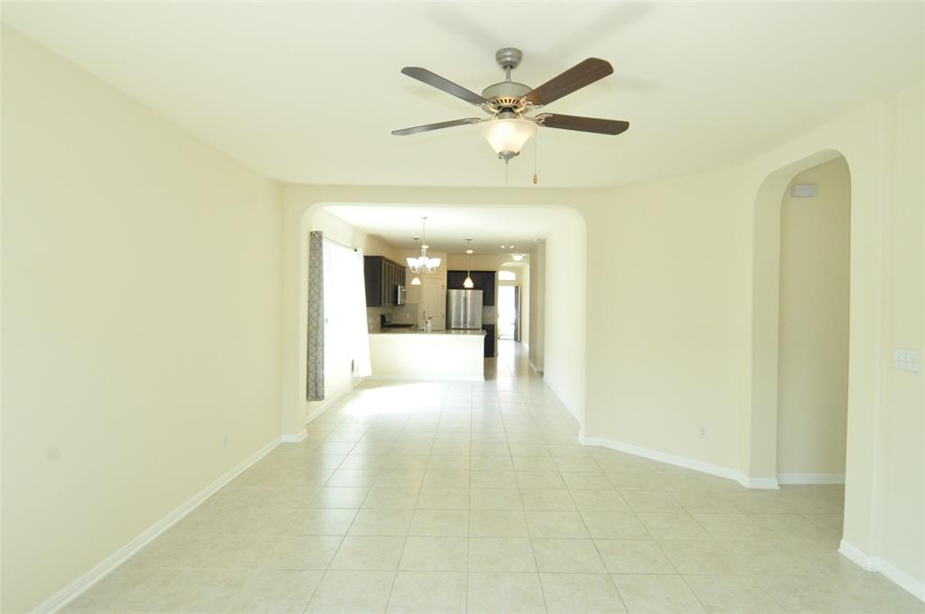 3451 Mayfield Ranch Boulevard, Unit 610 Round Rock, TX 78681 - Photo 8 of 19 Spare room featuring arched walkways, a chandelier, light tile patterned floors, and a ceiling fan