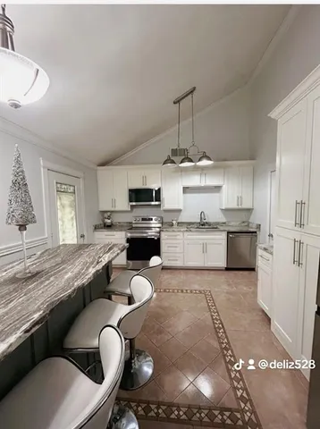 a kitchen with stainless steel appliances granite countertop a sink a stove and a refrigerator
