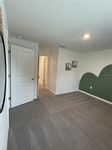 a view of a hallway with closet and a bathroom