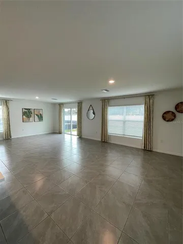 a large white kitchen with kitchen island a sink a counter top and a stove top oven