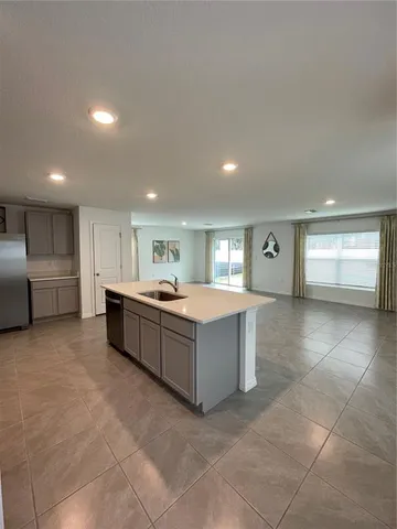 a large kitchen with a large counter top stainless steel appliances and cabinets