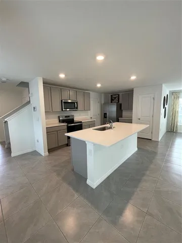 a view of a hallway to a room with wooden floor and a bathroom