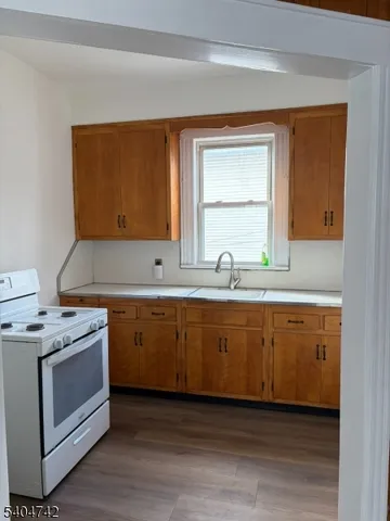 a kitchen with granite countertop cabinets stainless steel appliances a sink and a window