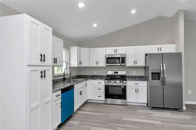 a kitchen with stainless steel appliances and white cabinets