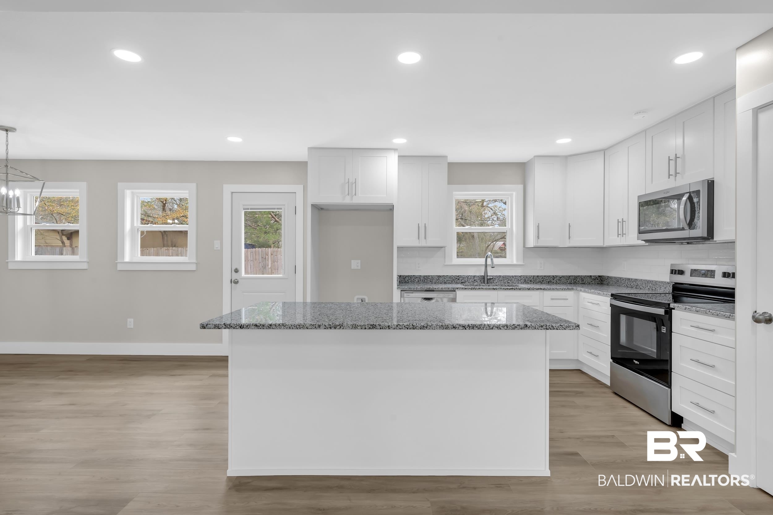 11381 Normandy Drive East Semmes, AL 36575 - Photo 8 of 23 Kitchen with stainless steel appliances, dark stone counters, a kitchen island, and white cabinetry