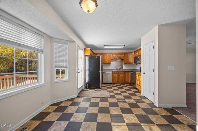 a kitchen with stainless steel appliances granite countertop a refrigerator a stove and a sink