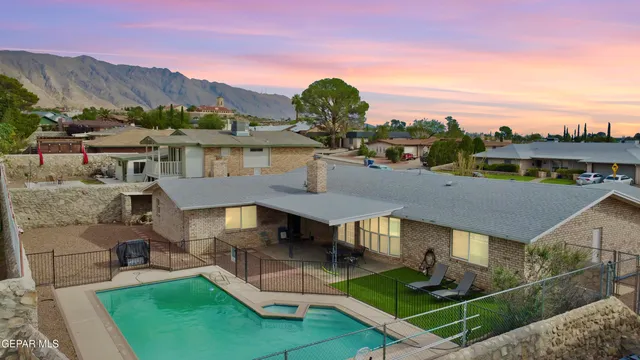 a view of a white house next to a yard with iron fence