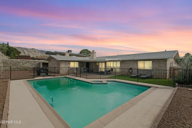 a view of a house with a swimming pool and a yard