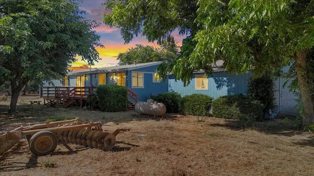 a view of backyard with a table and chairs under an umbrella