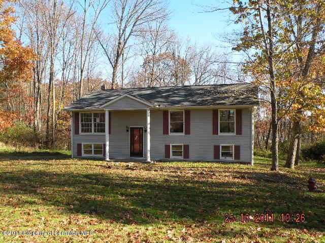 2136 Ross Road Dalton, PA 18414 - Photo 1 of 9 a front view of a house with a garden