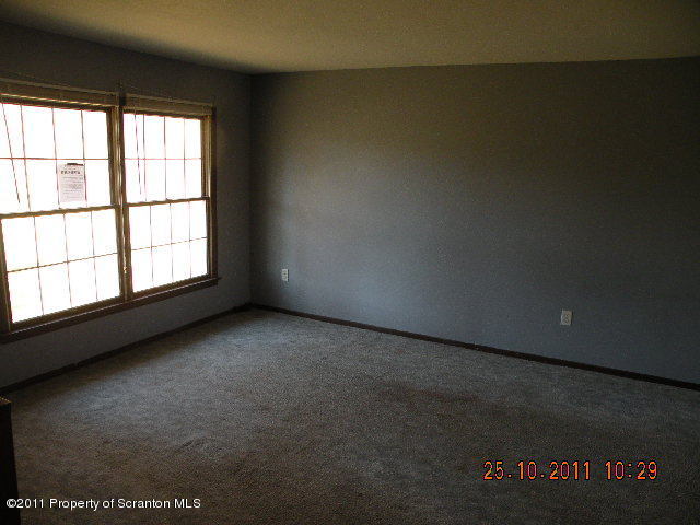 2136 Ross Road Dalton, PA 18414 - Photo 2 of 9 an empty room with wooden floor and windows