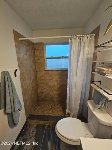 a bathroom with a toilet and a shower