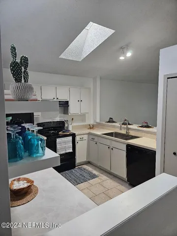 a kitchen with granite countertop a sink cabinets and stainless steel appliances