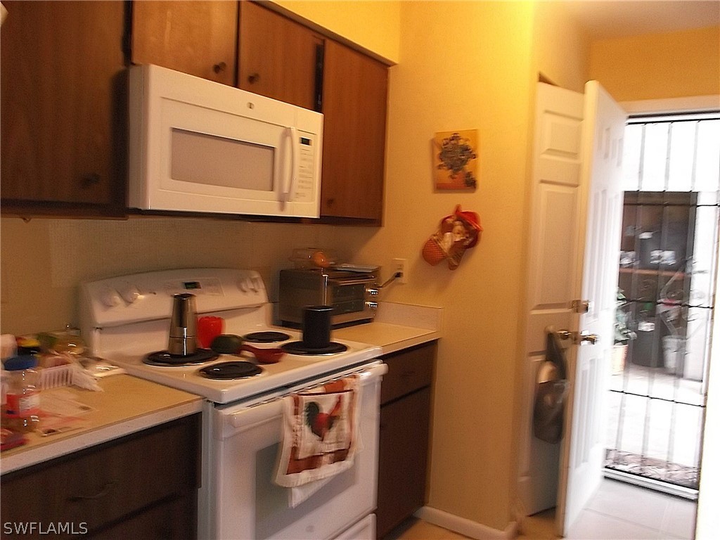 203 Davis Road Lehigh Acres, FL 33936 - Photo 8 of 10 a kitchen with a sink cabinets and appliances