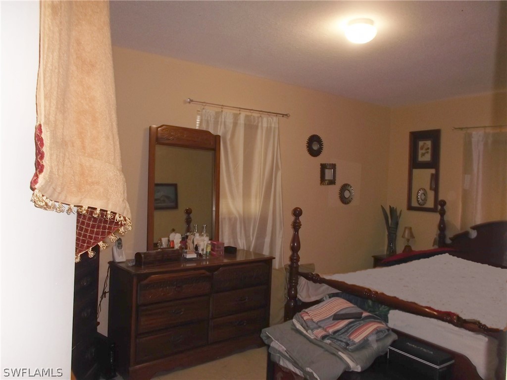 203 Davis Road Lehigh Acres, FL 33936 - Photo 9 of 10 a room with a bed and a mirror
