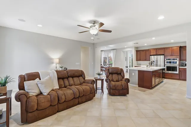 a kitchen with stainless steel appliances granite countertop a table chairs sink refrigerator and cabinets